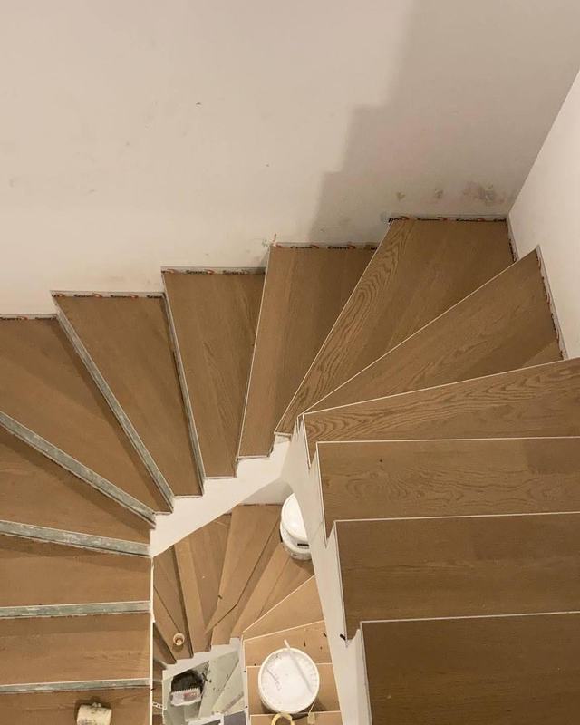 Escalier tournant habillé de marches en parquet clair