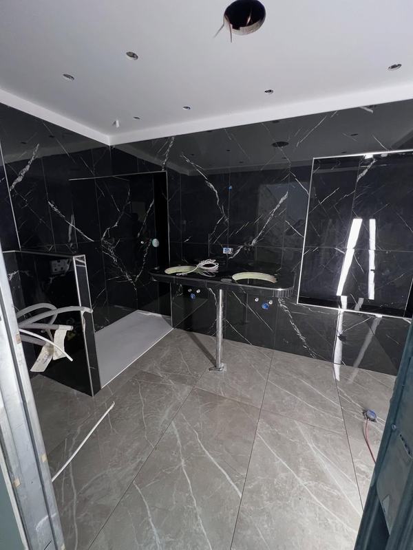 Salle de bain en grand format effet marbre noir veiné de blanc, sol gris